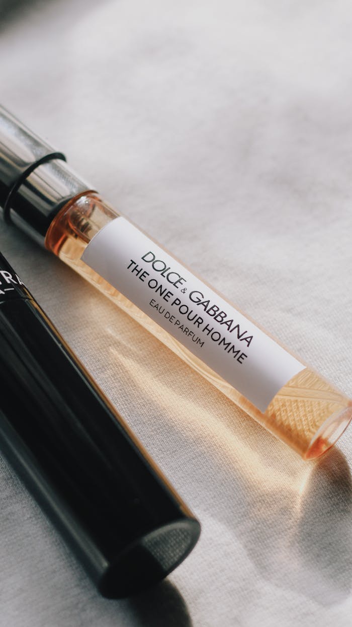 Close-up of two elegant perfume vials on a soft fabric background, showcasing luxury.