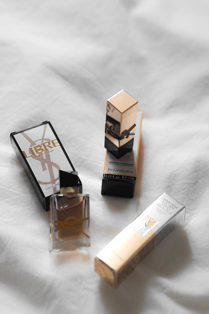 Minimalist display of Yves Saint Laurent LUX beauty products on a white surface.
